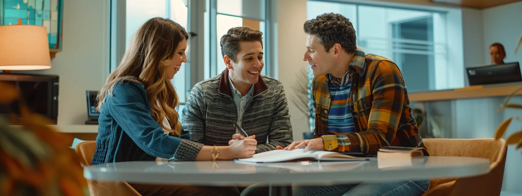 a young couple excitedly signing paperwork with a knowledgeable real estate agent in a modern, bright office setting.